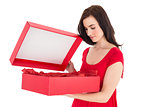 Stylish brunette in red dress opening gift