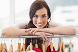 Smiling brunette smiling at camera by clothes rail