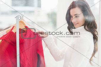 Pretty brunette looking at clothes on rail