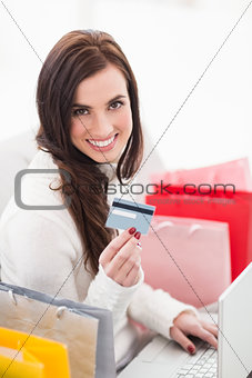 Brunette shopping online with laptop on the couch
