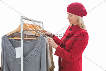 Pretty blonde looking at clothes on rail