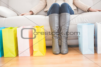 Woman sitting on couch with shopping bags