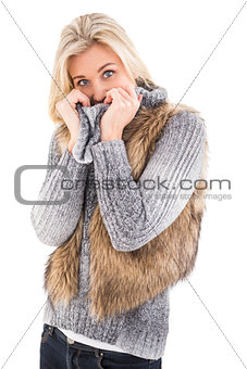 Blonde in winter clothes smiling at camera