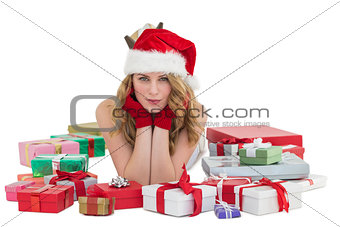 Woman in santa hat laying on the floor with gifts around her