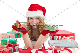 Woman in santa hat laying on the floor while holding gifts