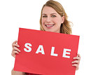 Cute blonde showing a red sale poster