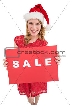 Pretty blonde in santa hat holding a red sale poster