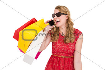 Pretty blonde talking on phone holding shopping bags