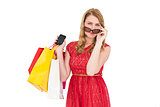 Cute woman holding shopping bags and her smartphone