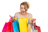Excited woman looking at camera with many shopping bags