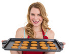 Smiling woman showing hot cookies