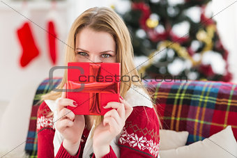 Young woman hiding behind a gift