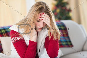 Sad woman sitting in the living room on a couch