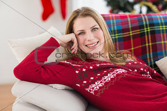 Content woman lying on the sofa smiling at camera