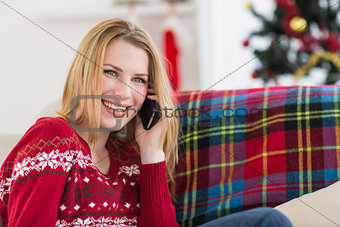 Happy woman relaxing on couch talking on phone