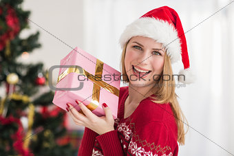 Smiling festive woman showing a pink gift