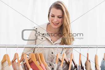 Pretty blonde looking through clothes rail