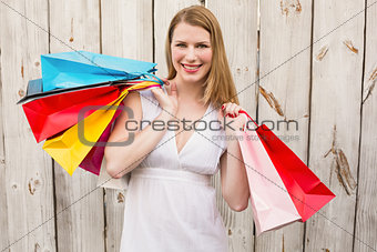 Smiling woman carrying shopping bags over her shoulder