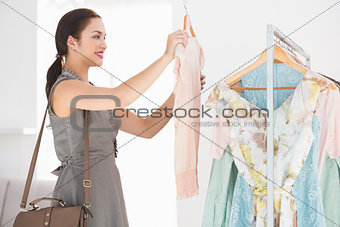 Happy shopping brunette looking at shirt