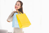 Happy brunette holding shopping bags