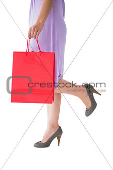 Mid section of woman holding red shopping bag