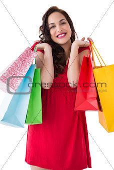 Elegant brunette in red dress holding shopping bags