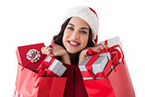 Excited brunette holding shopping bags full of gifts