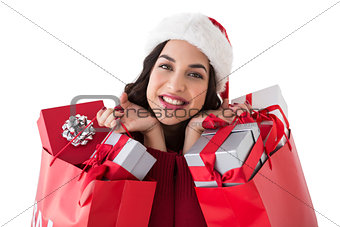 Excited brunette holding shopping bags full of gifts