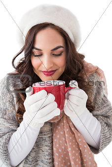 Brunette in winter clothes holding a mug