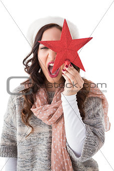 Excited brunette in winter clothes holding star