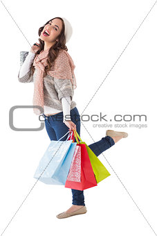 Excited brunette posing with shopping bag