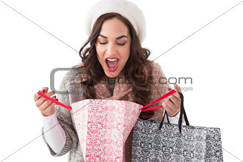 Surprised brunette looking in shopping bag