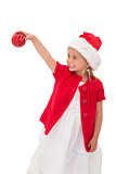 Cute little girl wearing santa hat holding bauble