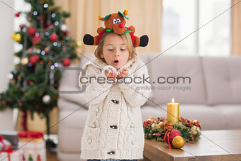 Festive little girl blowing over hands