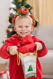 Festive little boy smiling at camera with gift