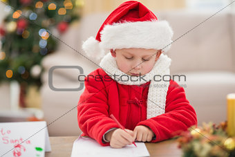 Festive little boy writing wish list