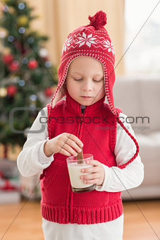 Festive little boy dipping cookie in milk