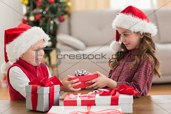 Festive siblings smiling at their gifts