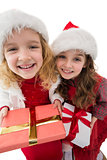 Festive little siblings smiling at camera holding gifts