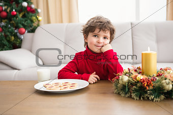 Festive little boy having milk and cookies