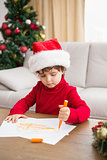 Festive little boy writing wish list