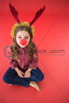 Festive little girl wearing red nose