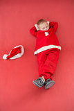 Little boy napping in santa costume