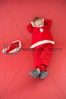 Little boy napping in santa costume