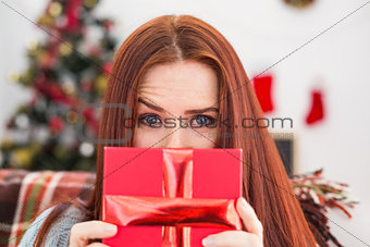 Festive redhead with gift on the couch