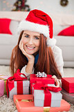 Festive redhead smiling at camera holding gift