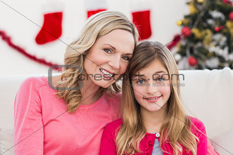 Festive mother and daughter smiling at camera