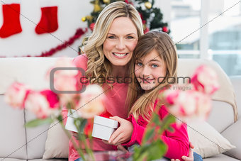 Little girl giving her mother a christmas gift