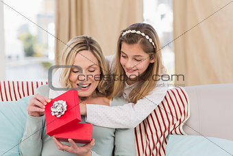 Mother opening christmas gift with daughter