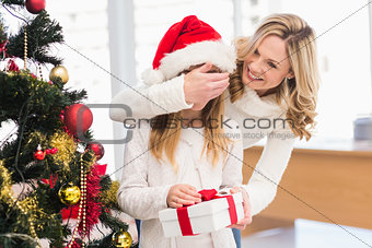 Festive mother and daughter beside christmas tree
